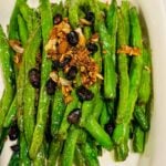 Stir-Fried bright Garlic Green Beans with black beans and toasted garlic on top.