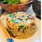A delicious plate of Shanghai fried rice featuring savory ground beef and chorizo, complemented by vibrant bok choy.