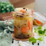 Mason jar filled with atchara, a traditional Filipino pickled green papaya relish, showcasing its vibrant colors and tangy flavor.