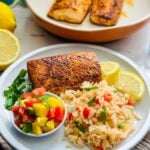 Plate featuring a blackened mahi mahi fillet served with creole rice and mango salsa, offering a colorful and flavorful seafood dish.