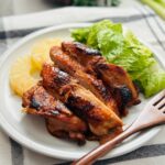 Huli-huli chicken, glazed and tender, served with sweet pineapple.