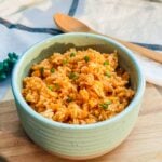 A bowl of colorful Filipino Java rice, seasoned with garlic, onion, and tomato paste for a vibrant red-orange hue.