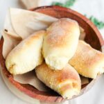 Soft and fluffy spanish bread on a wooden bowl.