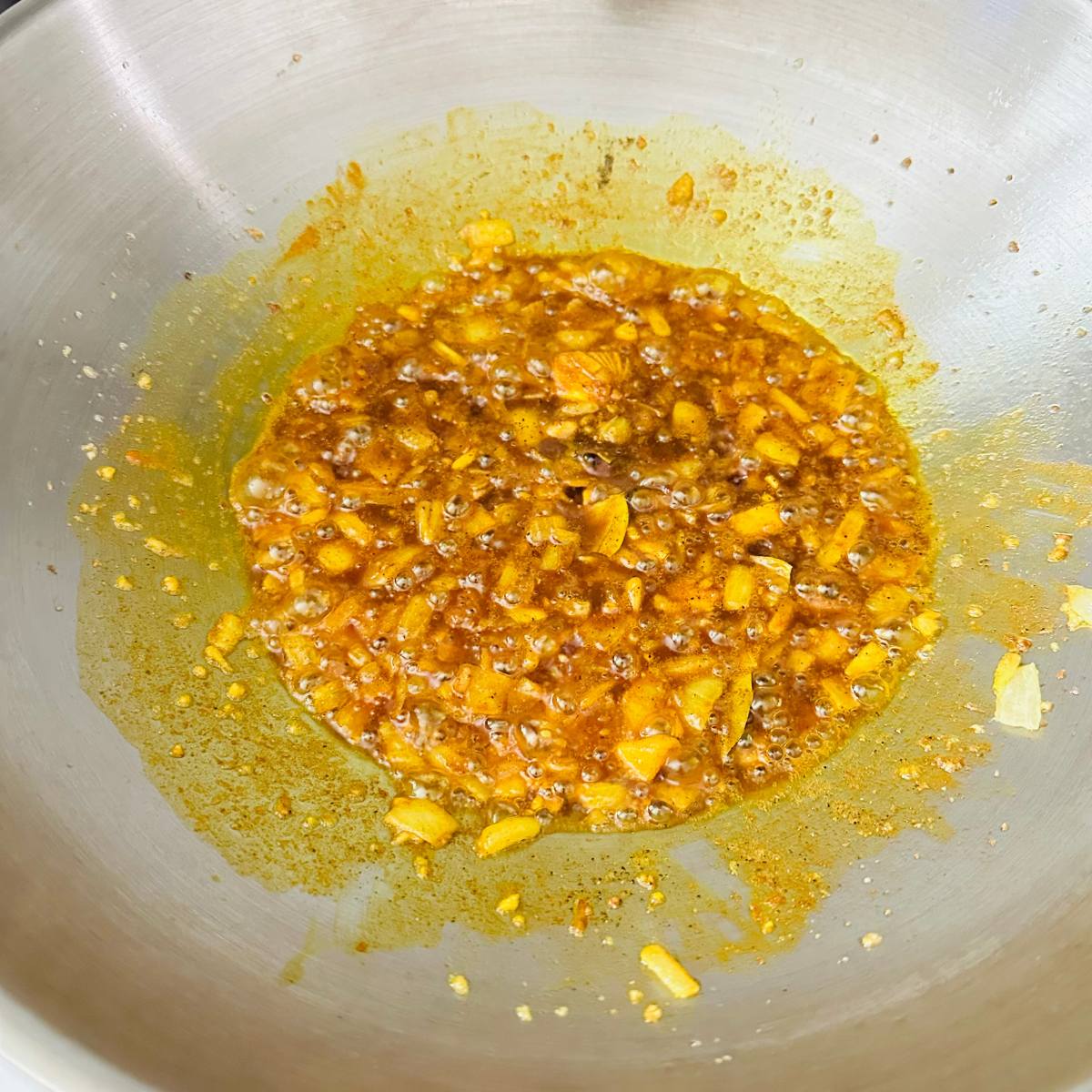 Turmeric and bay leaves stirred into sautรฉed garlic and onions.