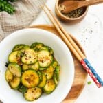 A traditional Korean side dish, cucumber salad (oi muchim), served on a plate with chopsticks.