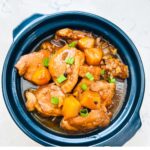 Chicken Adobo with Pineapple simmering in a claypot, featuring tender chicken pieces, pineapple chunks, and savory sauce.