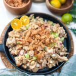 Chicken sisig on a sizzling plate topped with crispy chicharon (pork cracklings), served hot and sizzling.