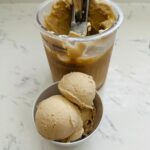 A bowl of Ninja Creami Coffee Ice Cream, featuring a smooth and creamy texture with a rich coffee flavor. The ice cream is a light brown color, with a velvety consistency.