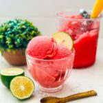Scoops of raspberry sorbet with slice of lime on top.