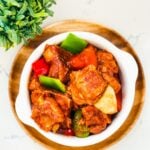 A bowl of savory pork spare ribs caldereta, a Filipino dish featuring tender ribs simmered in a rich tomato-based sauce.