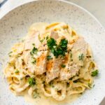 A plate of creamy Cajun Alfredo pasta with chicken. The pasta is coated in a rich, creamy sauce with a hint of spice, and the chicken is tender and juicy.