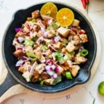 A sizzling plate of minced pork belly with onions, peppers, and mayonnaise.
