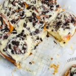 Homemade cookies and cream cinnamon rolls with a decadent cream cheese frosting and Oreo cookie crumbles.