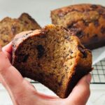 Close-up of a sliced moist chocolate chunk banana bread, showing the texture and chocolate chunks.