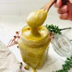 A glass jar filled with smooth, creamy pistachio cream.