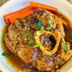 Tender braised beef shank served with thickened sauce ready to be served.