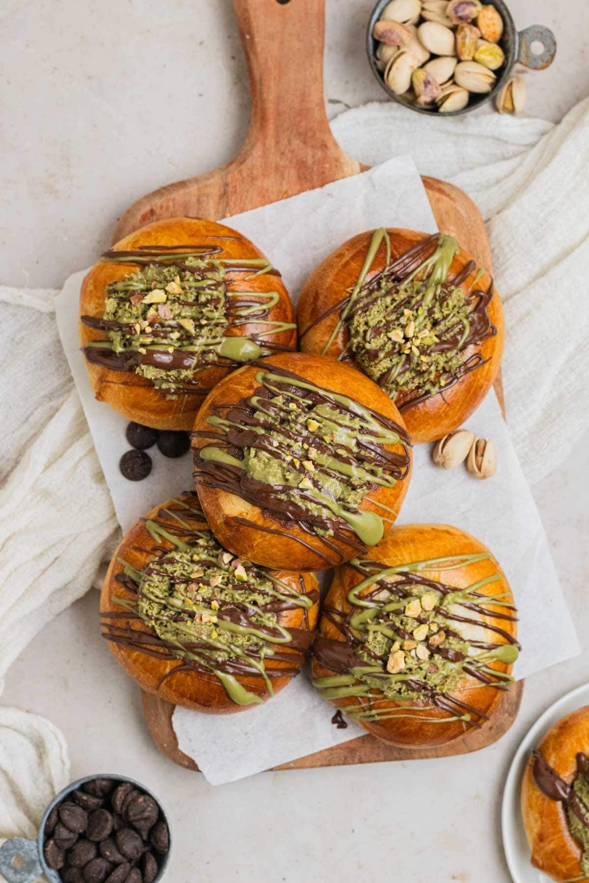 Dubai Chocolate Brioche Buns filled with creamy pistachio, topped with toasted kunafa for crunch, and featuring a soft, golden-brown brioche exterior.