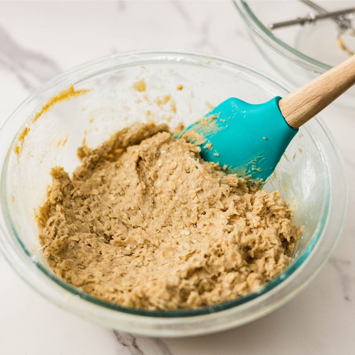 Combining wet and dry ingredients for brown butter oatmeal chocolate chip cookies.