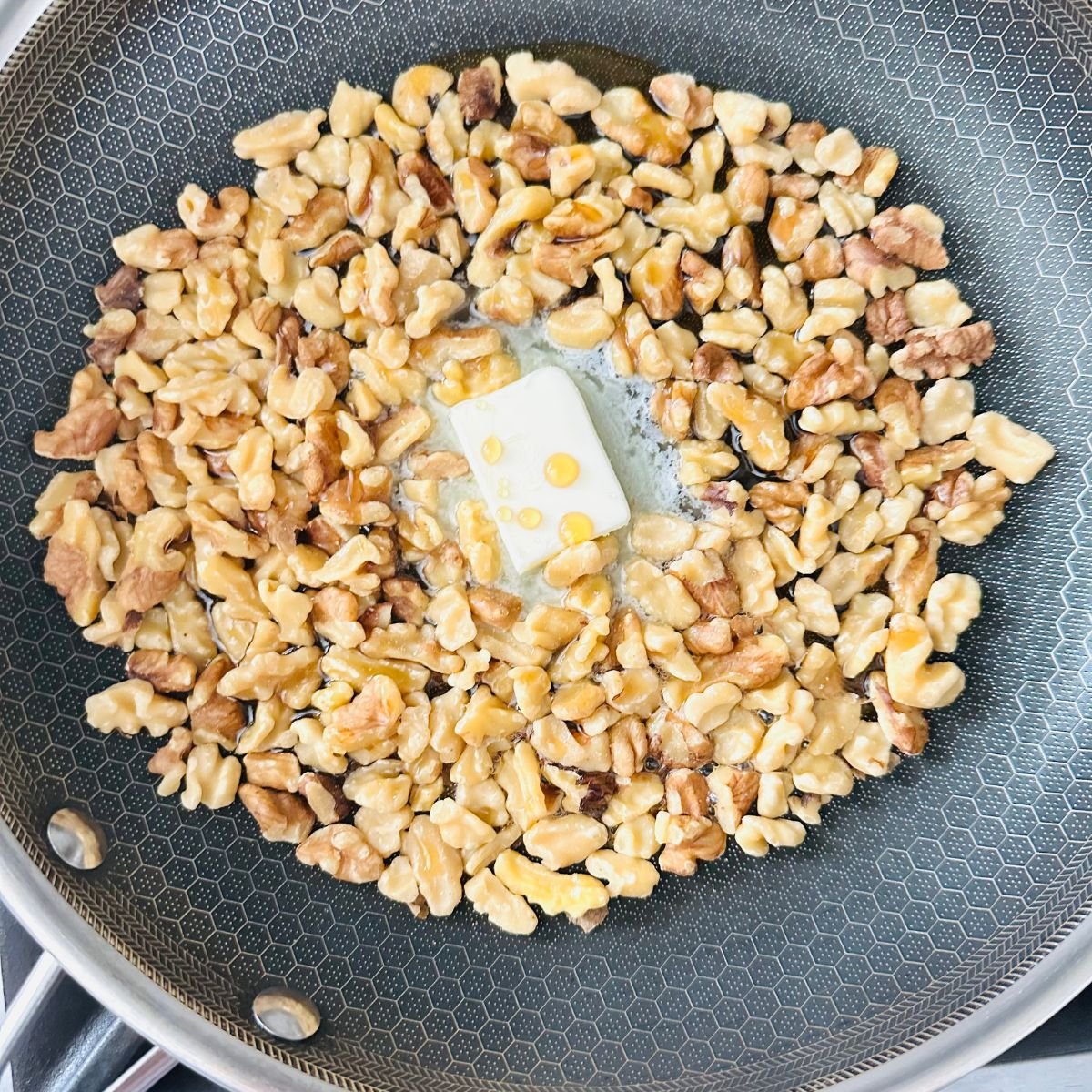 Ingredients in a nonstick skillet to start candied maple walnut recipe.
