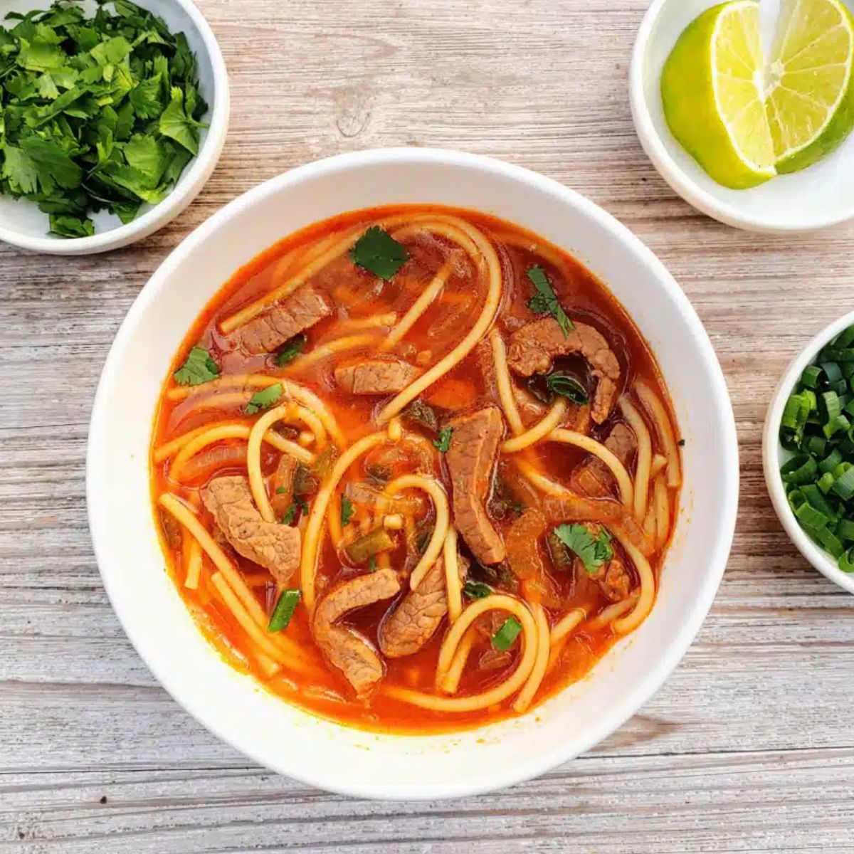 Steaming bowl of Spicy Thai Beef Noodle Soup with chili broth and herbs โ cozy quick beef soup for cold nights.