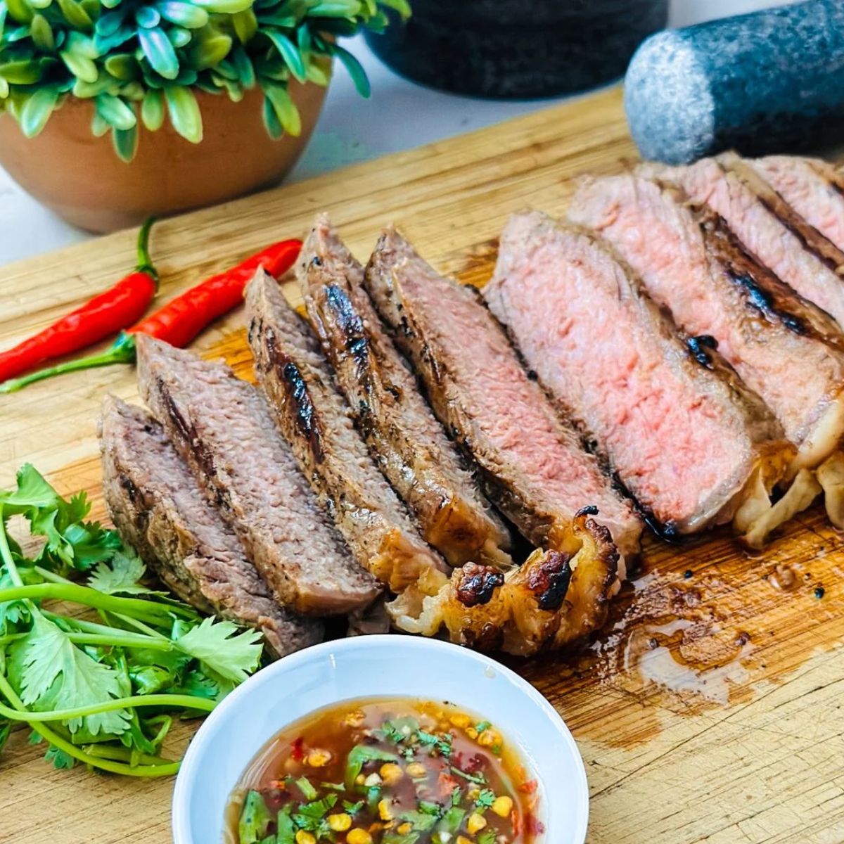 Thai Crying Tiger grilled beef slices served with spicy dipping sauce โ bold, flavorful Asian beef dish.