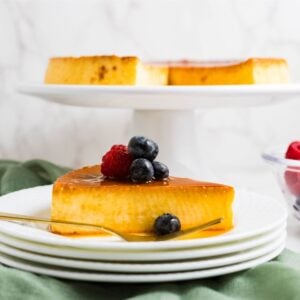 Slice of eggnog cream cheese flan on a plate with caramel sauce.