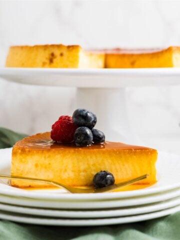 Slice of eggnog cream cheese flan on a plate with caramel sauce.