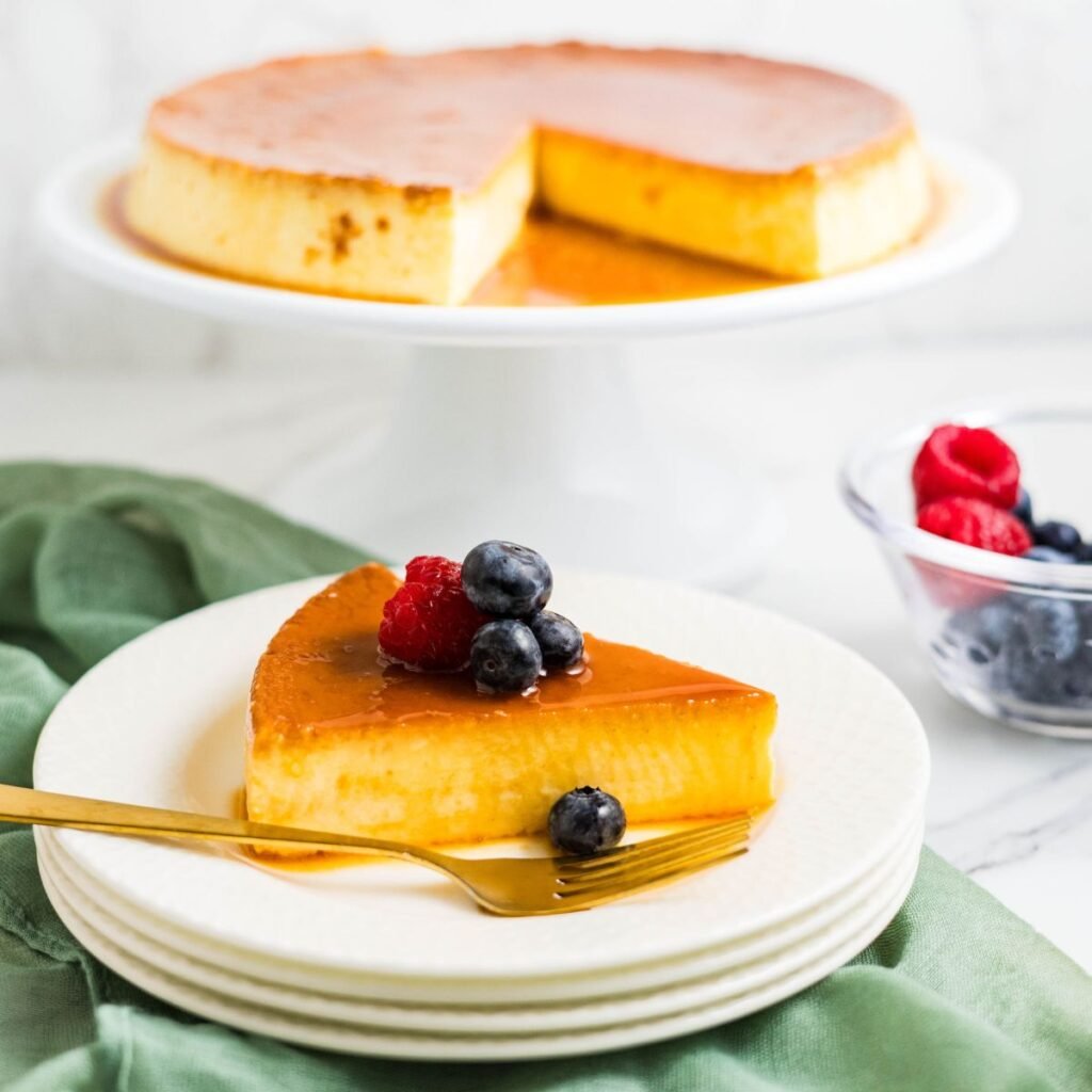 Slice of eggnog cream cheese flan on a plate with caramel sauce.