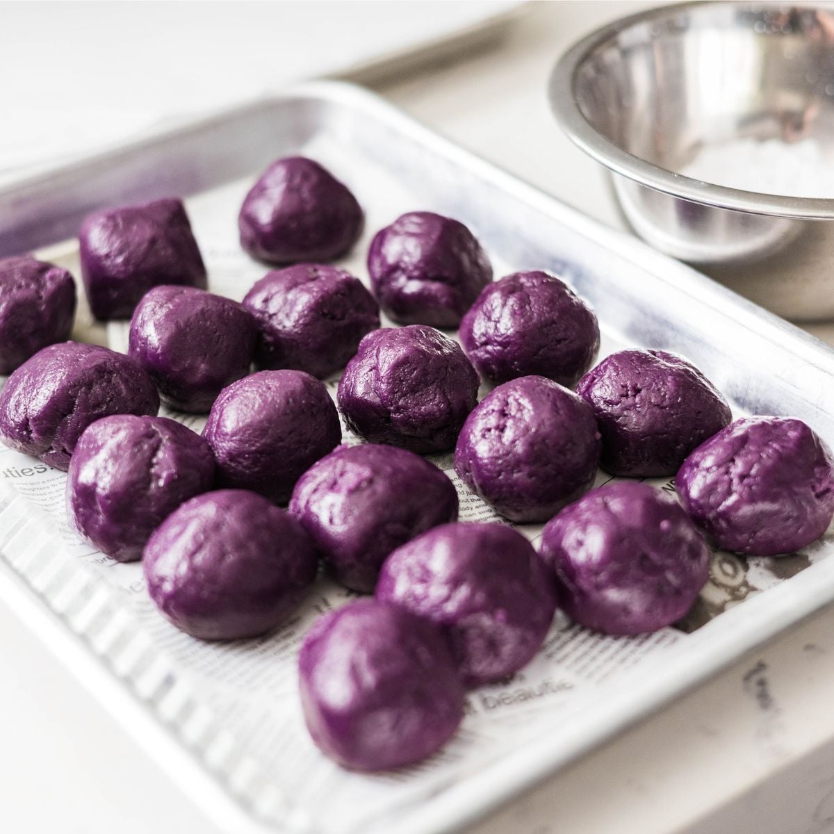 cooping heaping tablespoons of purple ube cookie dough balls, about 40 grams each.