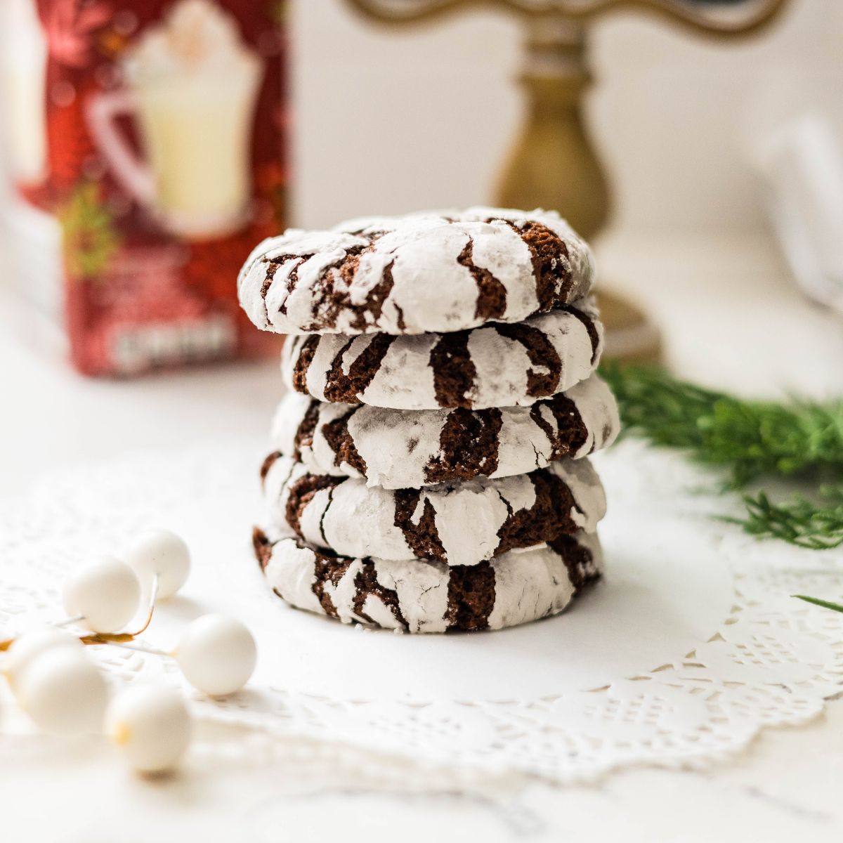 Pile of homemade chocolate crinkle cookies with crackled powdered sugar tops.