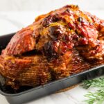 Spiral ham baked with orange marmalade and maple syrup glaze, caramelized edges and shiny finish.