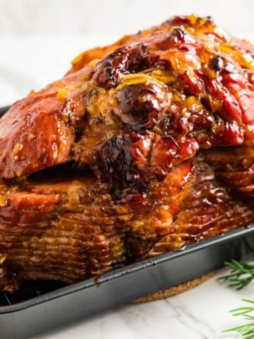 Spiral ham baked with orange marmalade and maple syrup glaze, caramelized edges and shiny finish.