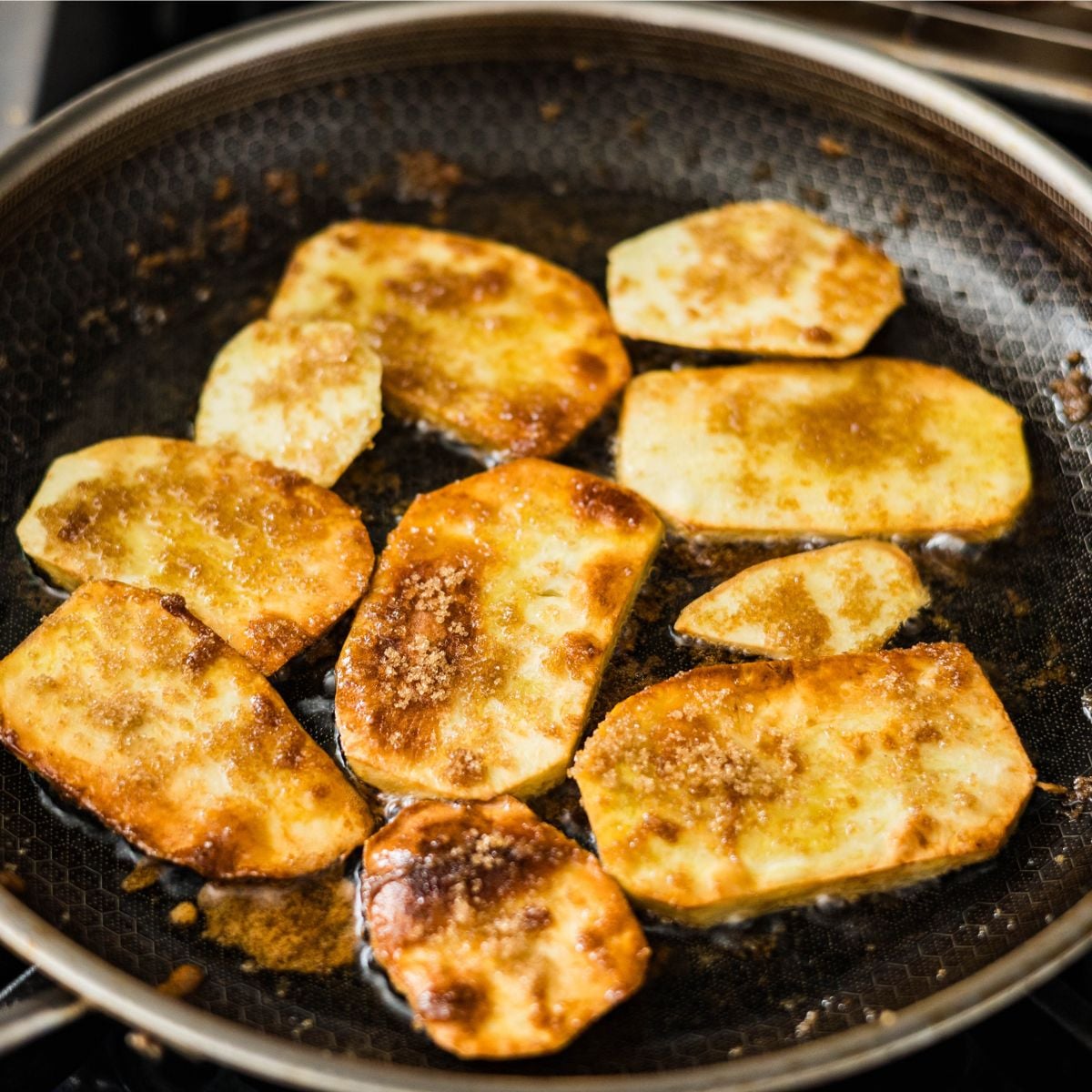 camote cue cooking with brown sugar caramelizing sweet potatoes in pan