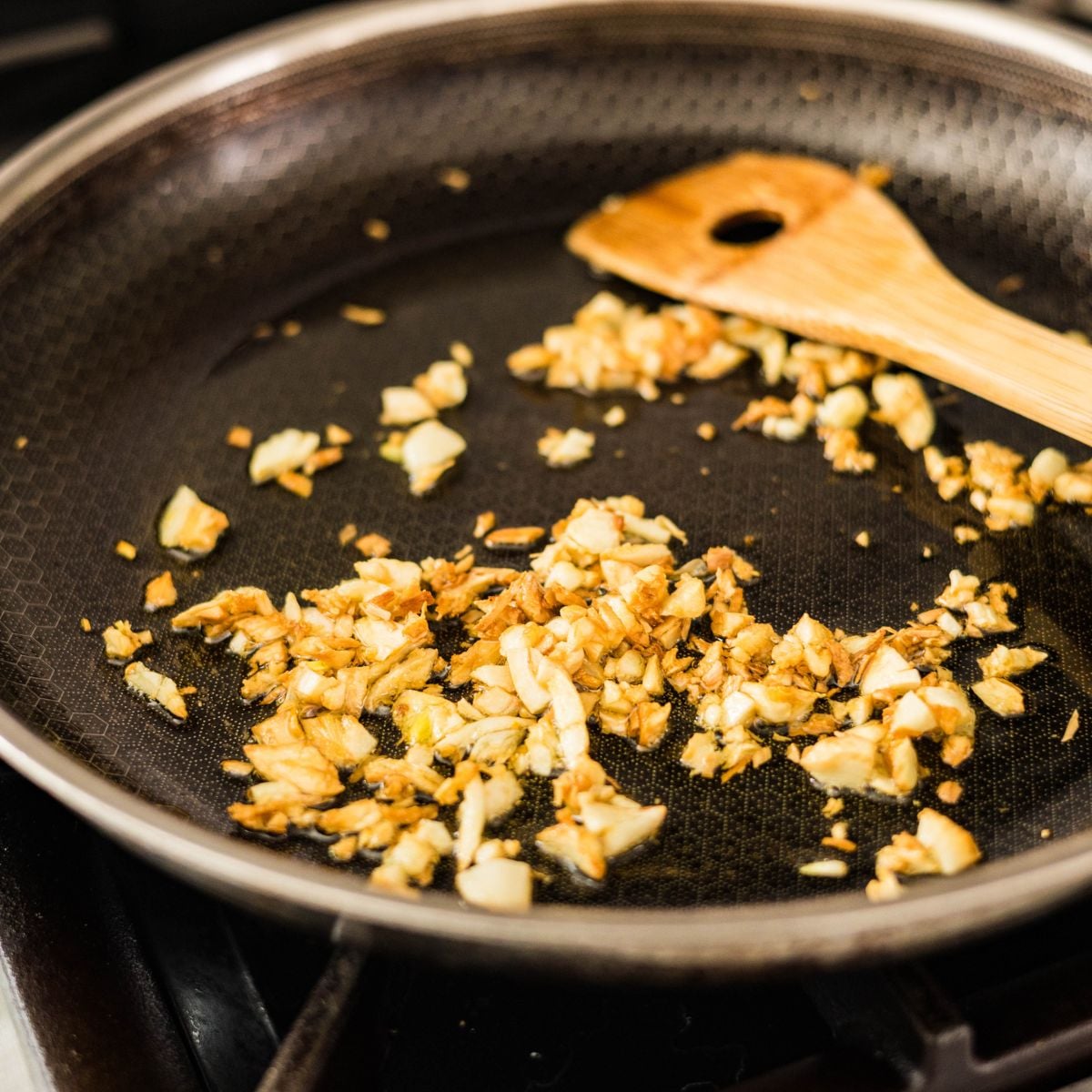 Chopped garlic frying in oil until golden and crispy for Filipino beef salpicao.