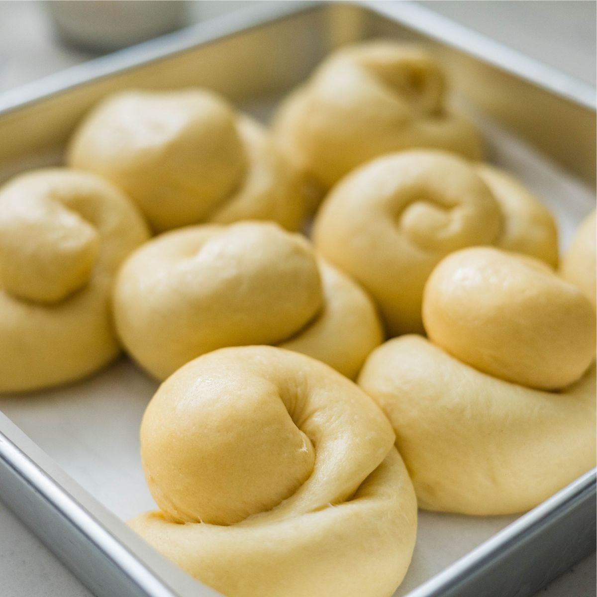 Filipino ensaymada dough during second proofing in a baking pan