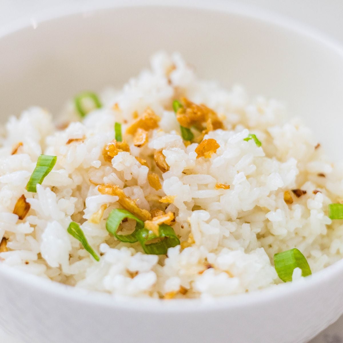 Close-up of Filipino garlic fried rice sinangag with toasted garlic and scallions.