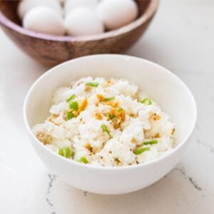 White bowl of Filipino garlic fried rice made with leftover rice and crispy garlic.