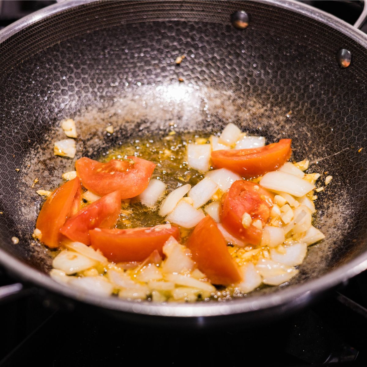 Tomatoes added to sautéed garlic and onion for ginisang sayote.