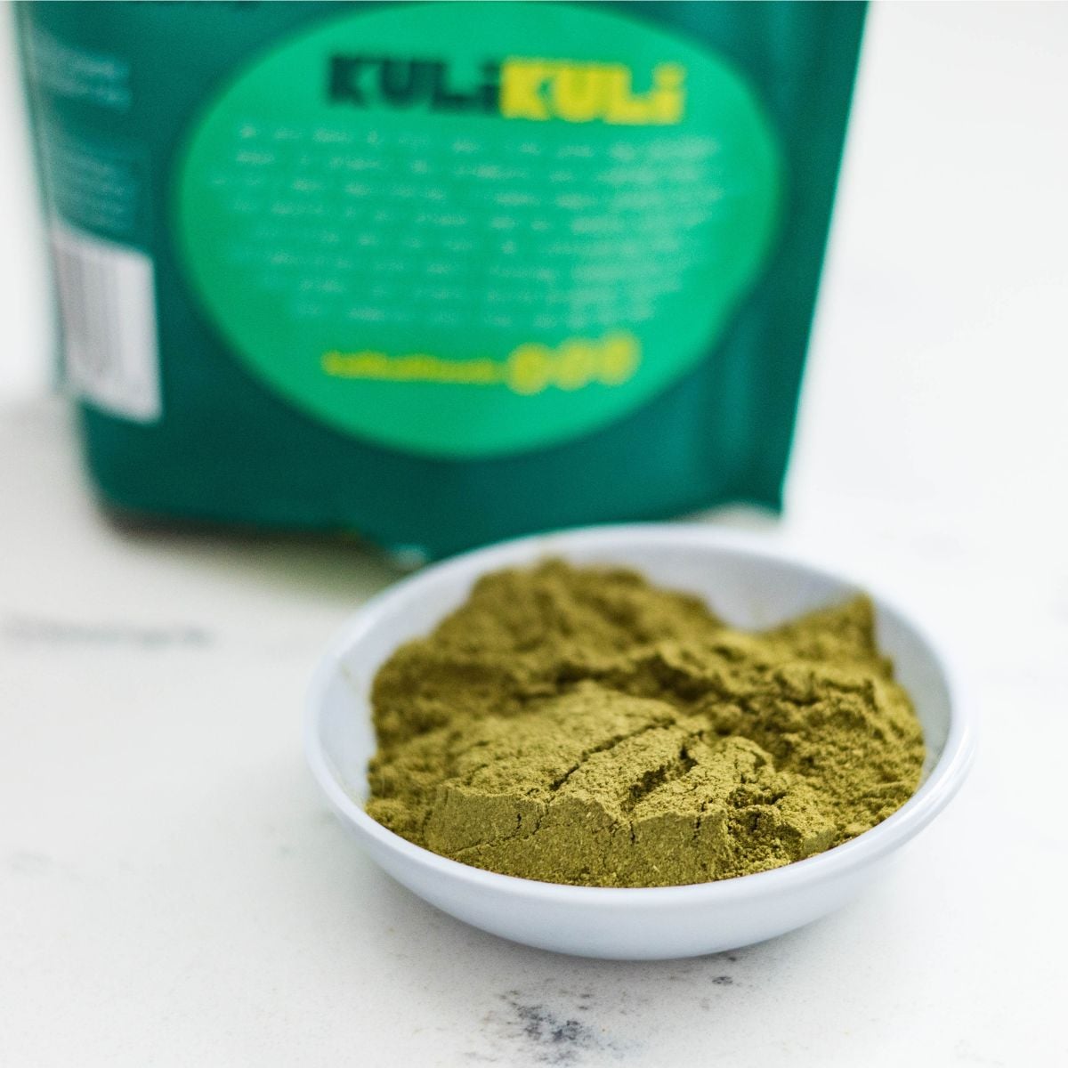 Close-up of malunggay powder also known as moringa powder in a small white dish.