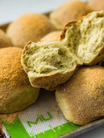 Close-up of torn malunggay pandesal showing the soft fluffy inside.