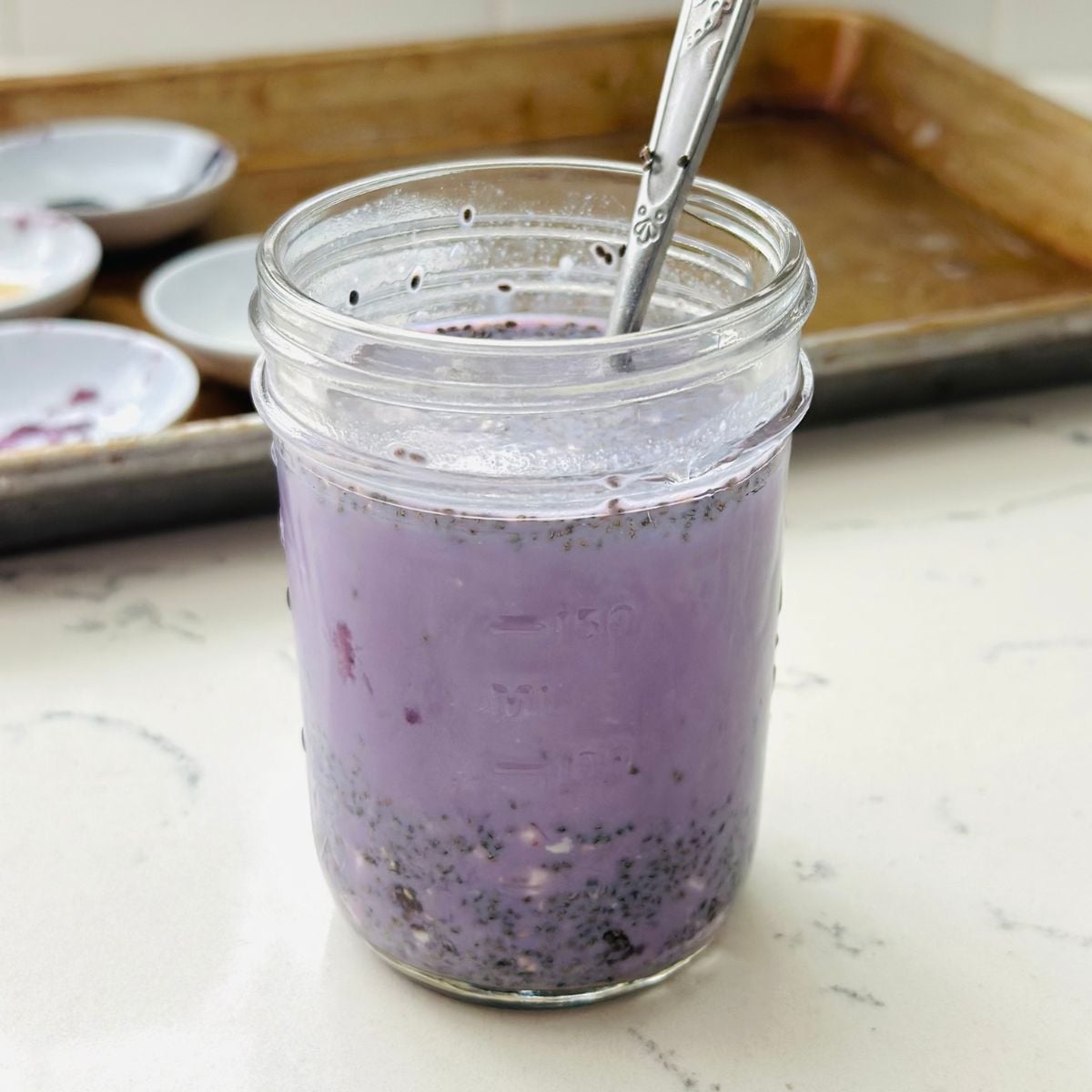 Ube chia pudding in a glass jar before chilling, made with milk, chia seeds, cottage cheese, honey, ube halaya, and ube extract