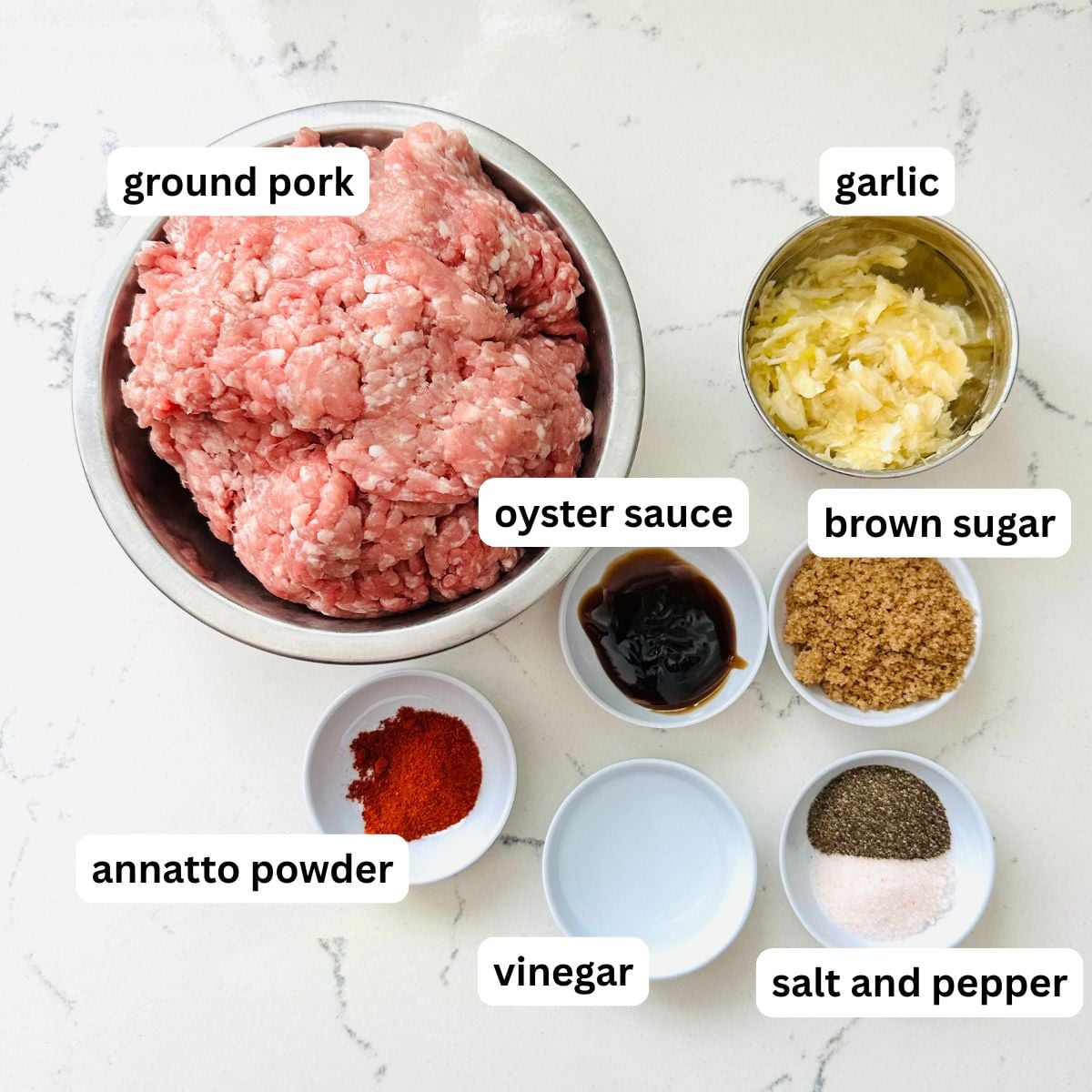 Raw ingredients for Vigan longganisa including ground pork, garlic, brown sugar, vinegar, oyster sauce, annatto powder, salt, and pepper