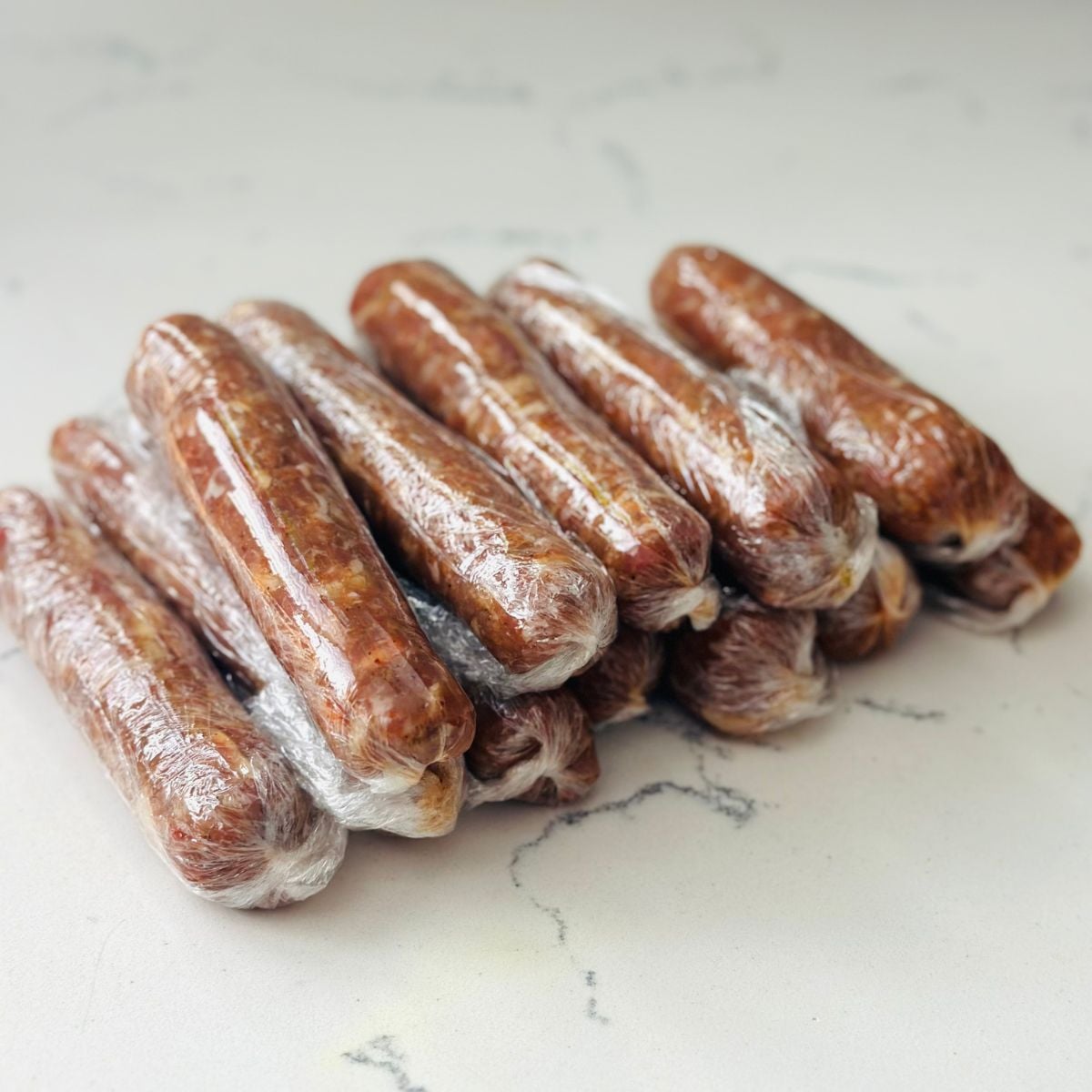 Homemade Vigan longganisa wrapped individually in plastic wrap ready for storage