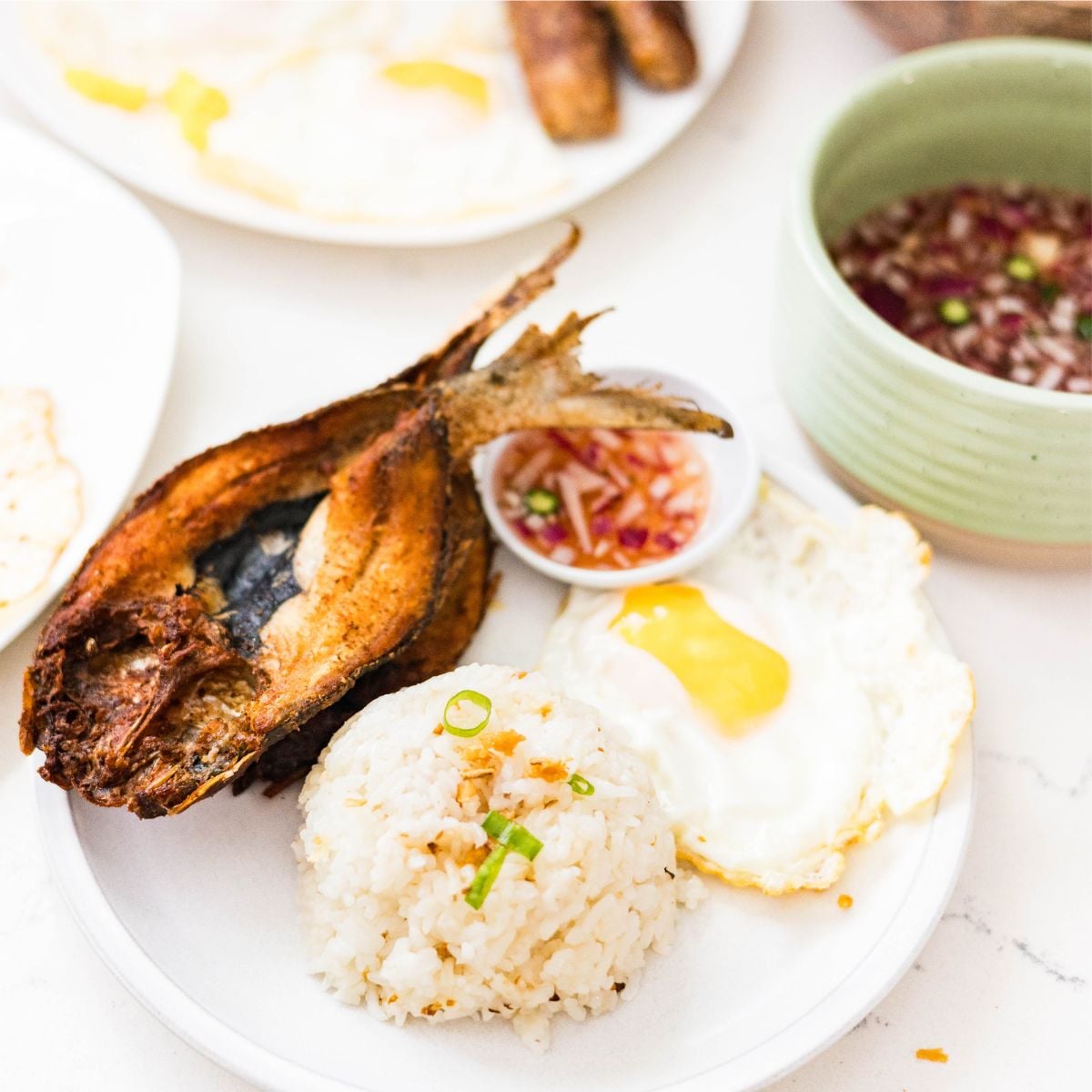 Fried bangus with garlic rice, fried egg, and Filipino vinegar dipping sauce
