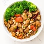 Close-up of cashew chicken with broccoli, red bell peppers, sesame seeds, and toasted cashews.