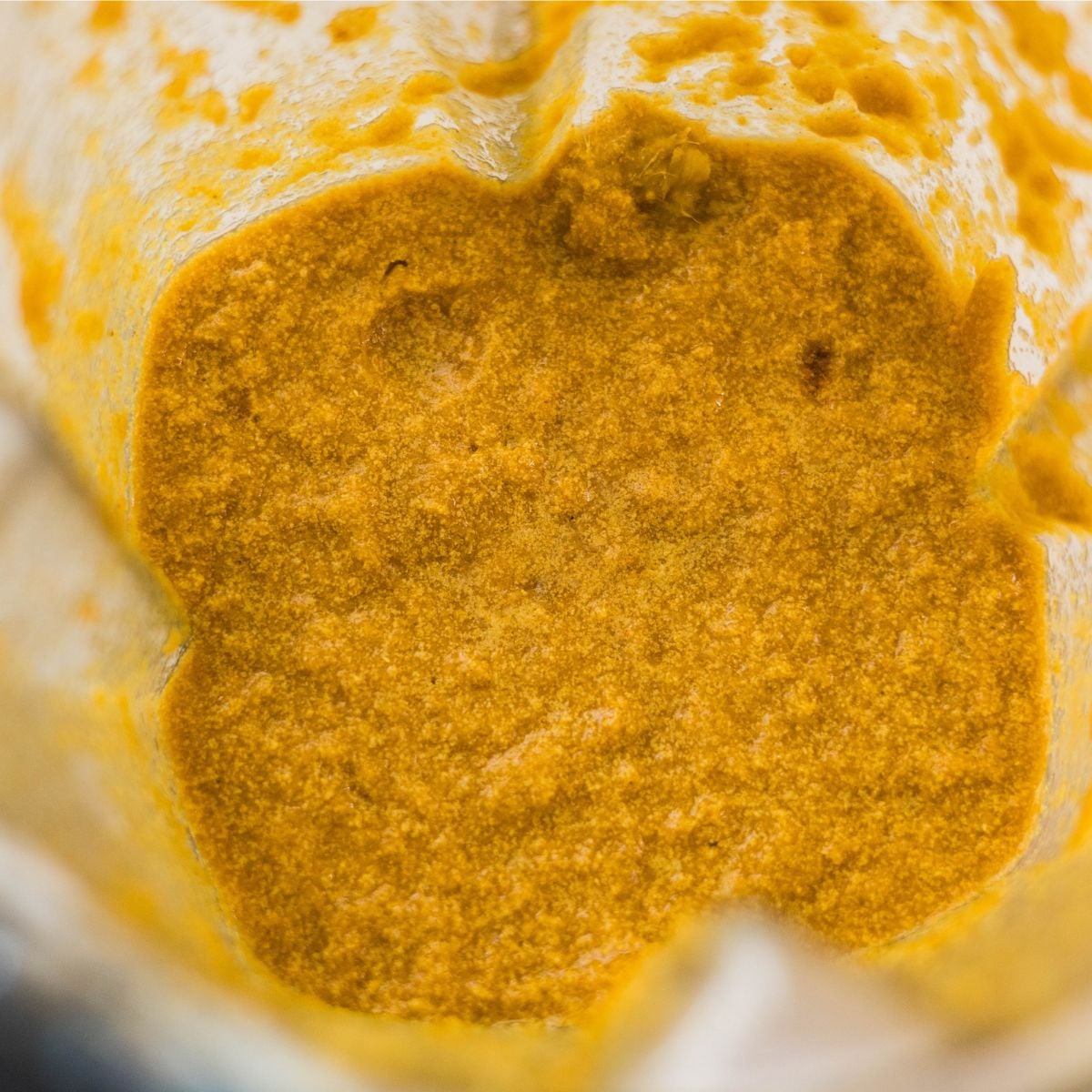 Blended yellow chicken satay marinade with turmeric, spices, and aromatics inside a blender.