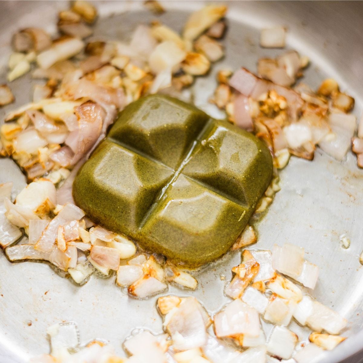 apanese curry roux block melting into sautรฉed onions and garlic.