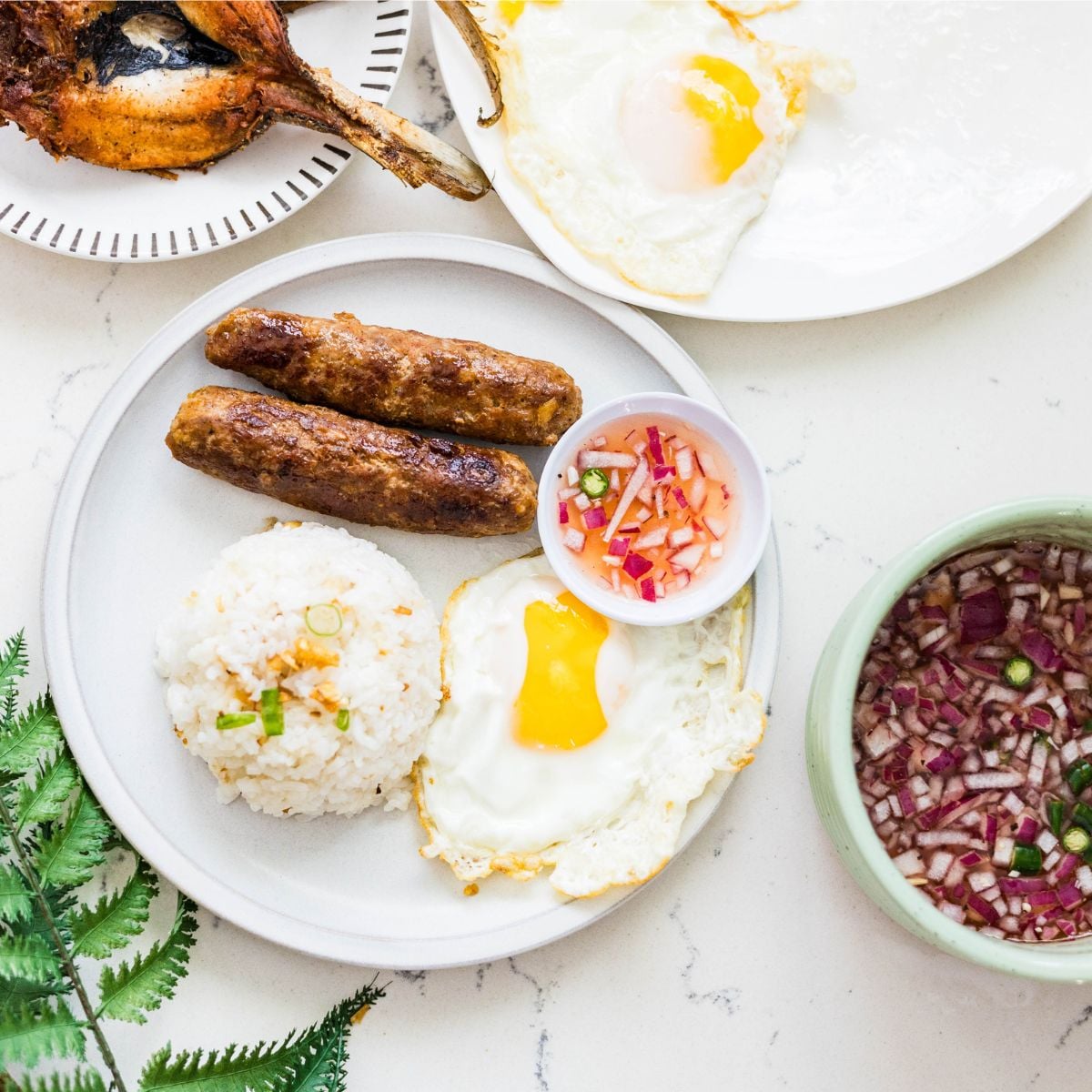 Longsilog plate with longganisa, garlic rice, fried egg, and sukang sawsawan dipping sauce