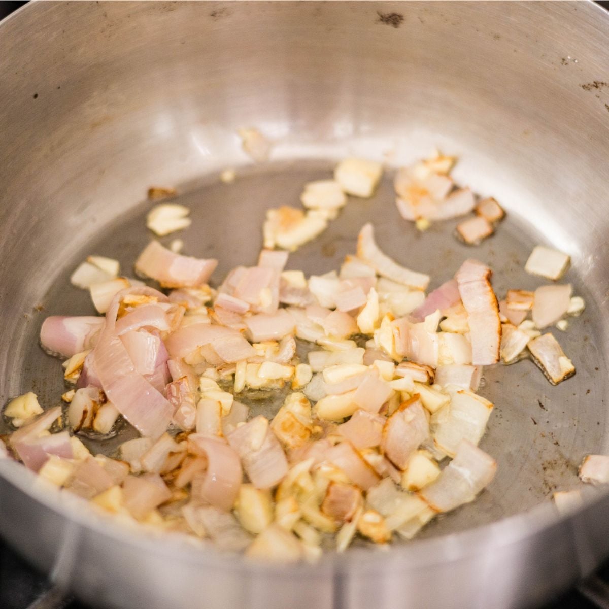 Chopped onions and garlic sautรฉing in a pot for Japanese beef curry.