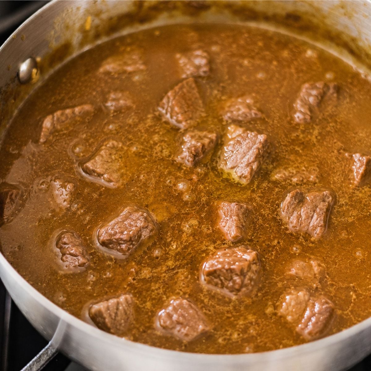 Beef broth being poured into the pot for Japanese beef curry.
